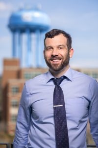 Picture of Dr Ross Boyce with a city skyline on the background